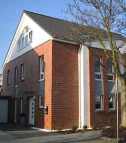 Doppelhaushälfte Haustyp A aus rotem Klinker mit weißem Giebel
